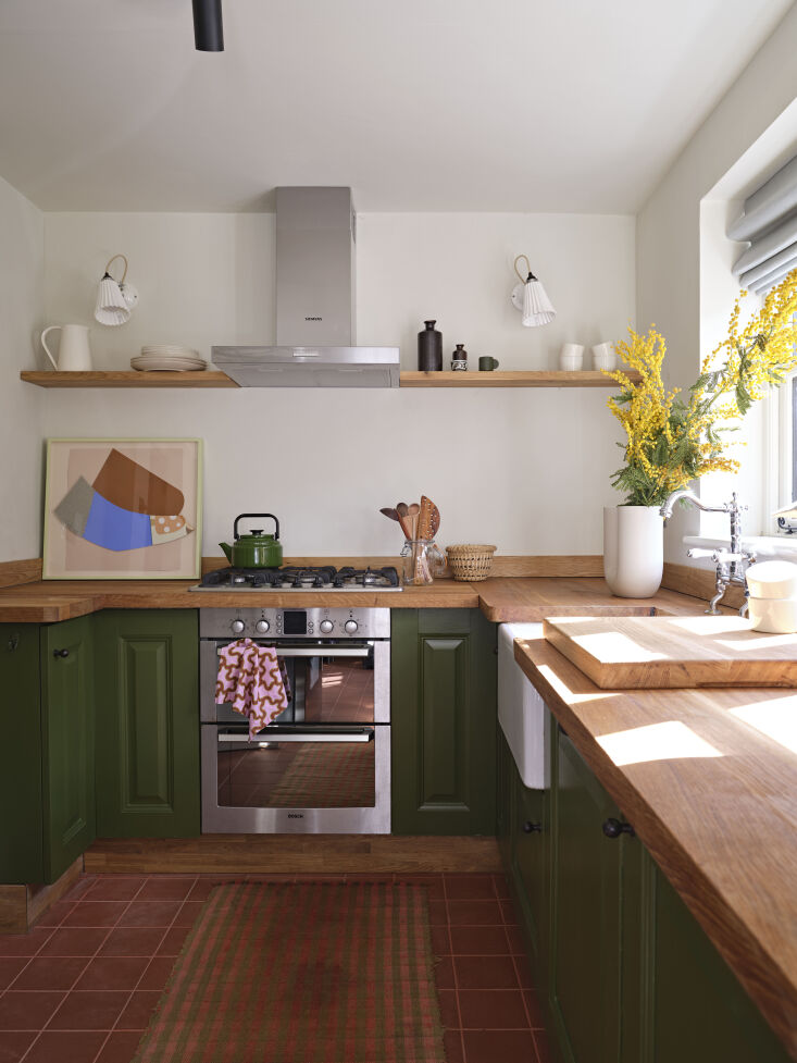 Learn the details of how this kitchen was transformed with a coat of paint, new floor tiles, and a new butcher counter. Photograph by Beth Evans, from Mill Lodge: A Colorful Cottage Escape for a Young Family.