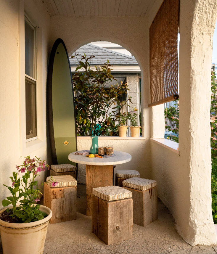 A pot of Nicotiana mutabilis, which Donati loves for its beautiful flower and whimsical shape, brightens the front porch. The dining stools and table base were fabricated by Tri-Lox, a Brooklyn studio that designs with sustainably-sourced wood; the table is topped with a circle of Carrera marble.