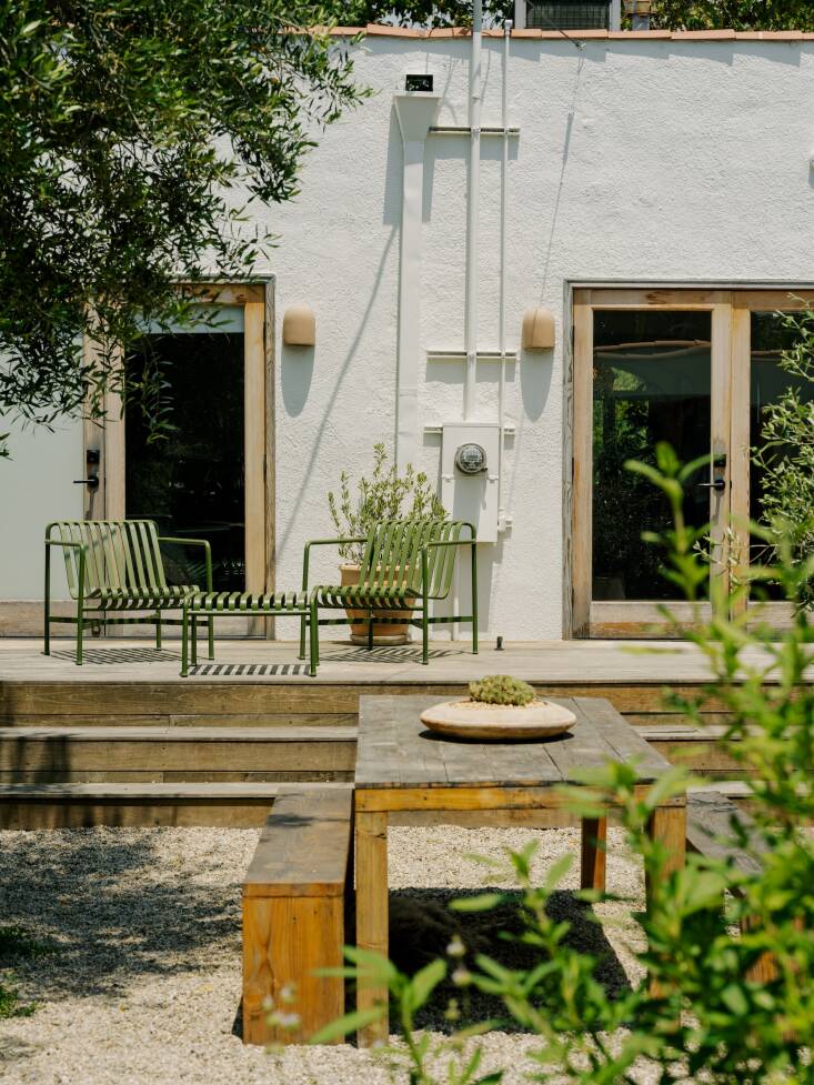 The green lounge chairs and table are the HAY Palissade collection. The outdoor table was a Rose Bowl Flea Market find made of wood reclaimed from old Los Angeles homes. Photograph by Austin John for Finca Glenfeliz.