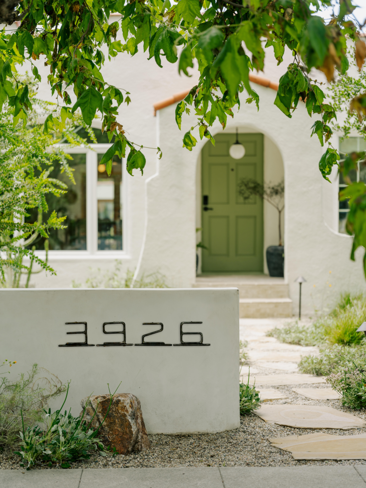 The house numbers are ORCA Custom House Numbers made from welded rod steel in a contemporary typeface. Stephanie and Daniel painted the house exterior and retaining walls themselves in Benjamin Moore Swiss Coffee. Photograph by Austin John for Finca Glenfeliz.