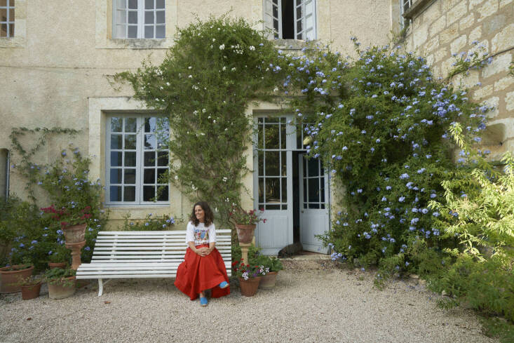 Victoire on a white Fermob bench, which takes its cues from the classic French park bench. Photograph courtesy of L’Officine Universelle Buly from Garden Visit: A Family Vegetable Garden in Gascony, France, Inspires a New Line of Fragrances.