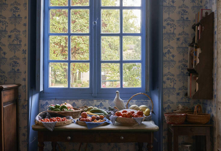 A view onto the potager from the tiled kitchen equipped with a full harvest corraled into linen-lined woven baskets. Photograph courtesy of L’Officine Universelle Buly from Garden Visit: A Family Vegetable Garden in Gascony, France, Inspires a New Line of Fragrances.